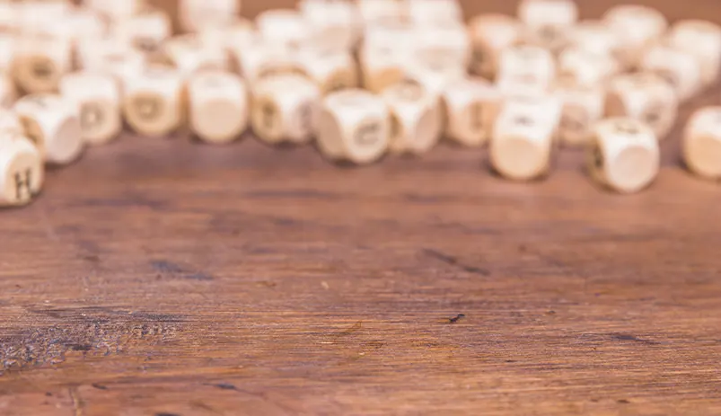 Buchstabenwürfel auf Holztisch